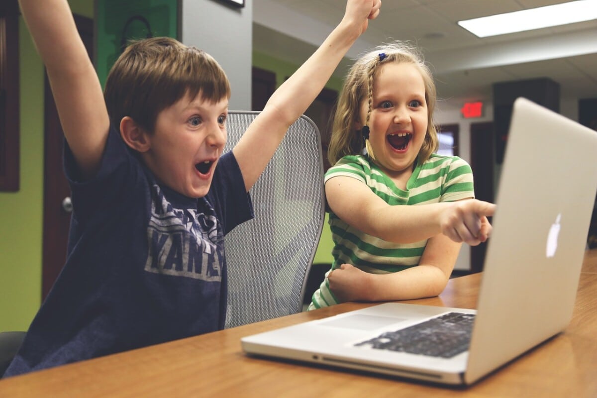 Kinder, die glücklich vor einem Laptop sitzen