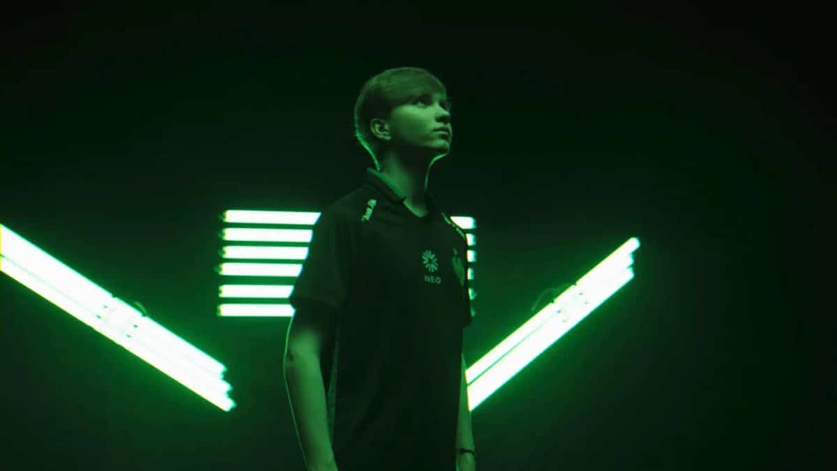 Porträt von Ilya „m0NESY“ Osipov in einem Trikot von Team Falcons vor einem Hintergrund mit grünem Neonlicht.