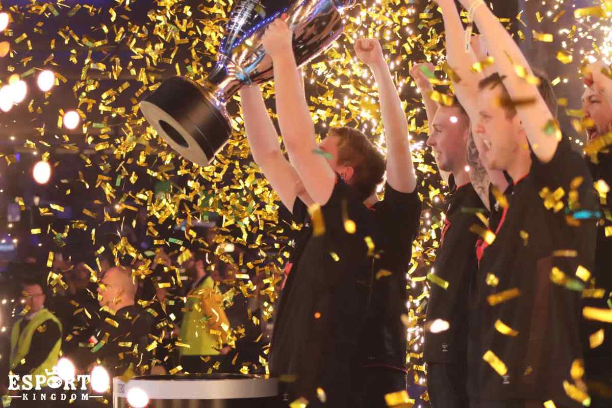 Integrantes del equipo de esports Astralis celebran con un trofeo entre confeti dorado que cae.