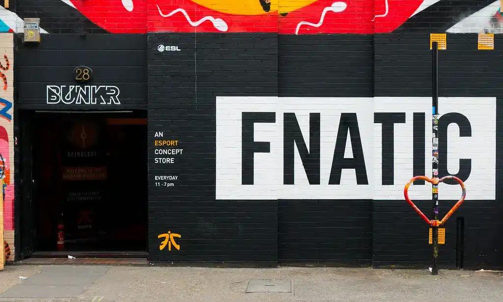 El exterior de una tienda conceptual de esports de Fnatic con el nombre de la organización en letras negras grandes sobre un fondo blanco.