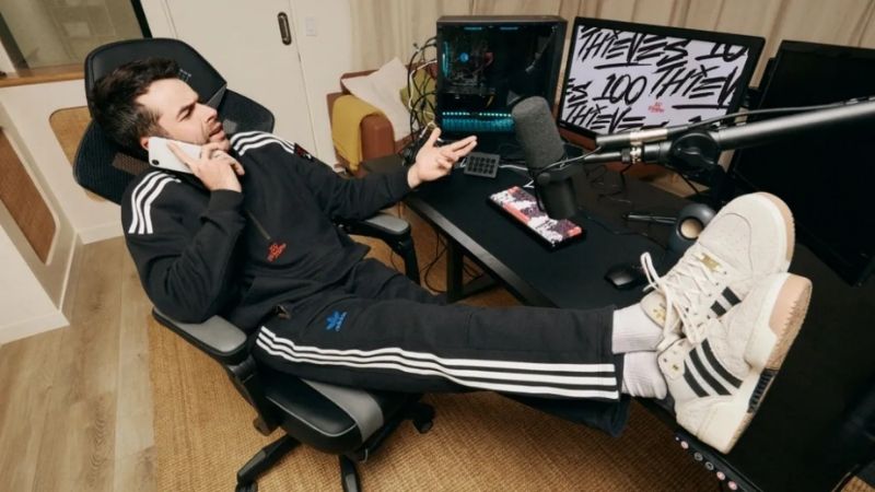 100 Thieves-medlem pratar i telefonen vid skrivbordet