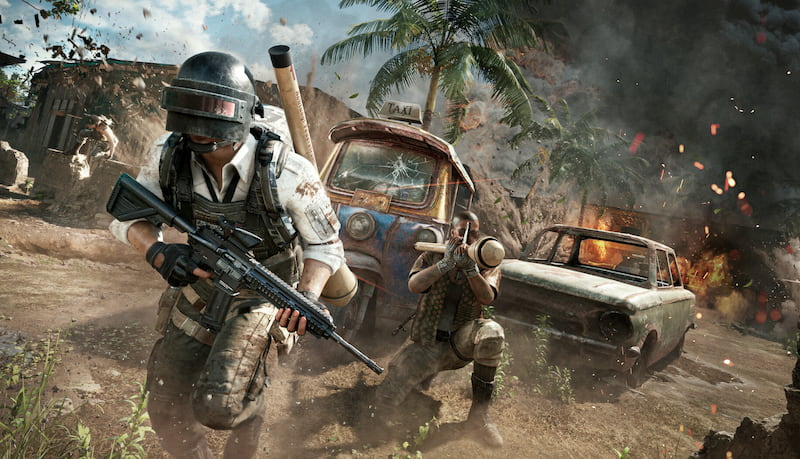 Två beväpnade karaktärer från PUBG: Battlegrounds står framför två fordon, redo för strid i en öppen landskapsmiljö.