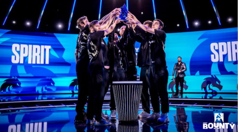 Team Spirit firar segern genom att tillsammans hålla upp en stor pokal på scenen under ett e-sportsevenemang.