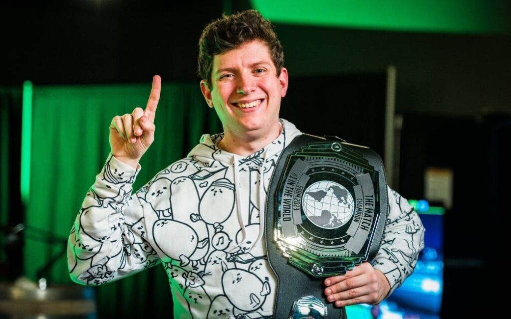 Cody står stolt med ett prisbälte efter att ha vunnit en turnering, ett symboliskt ögonblick av triumf och prestation