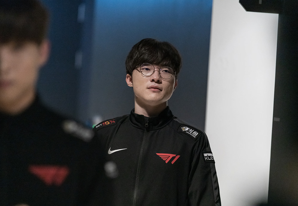 Faker i T1-jacka, tittar in i kameran.
