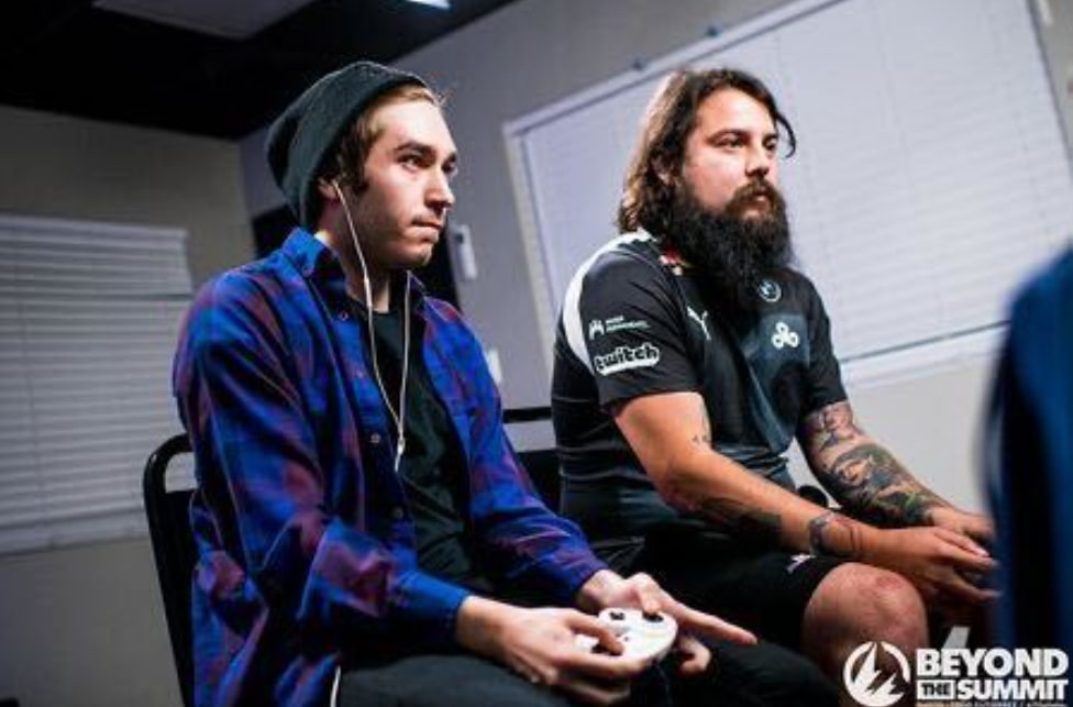 Spelaren Moky sitter och spelar Super Smash Bros. vid sidan av en annan spelare under en turnering.