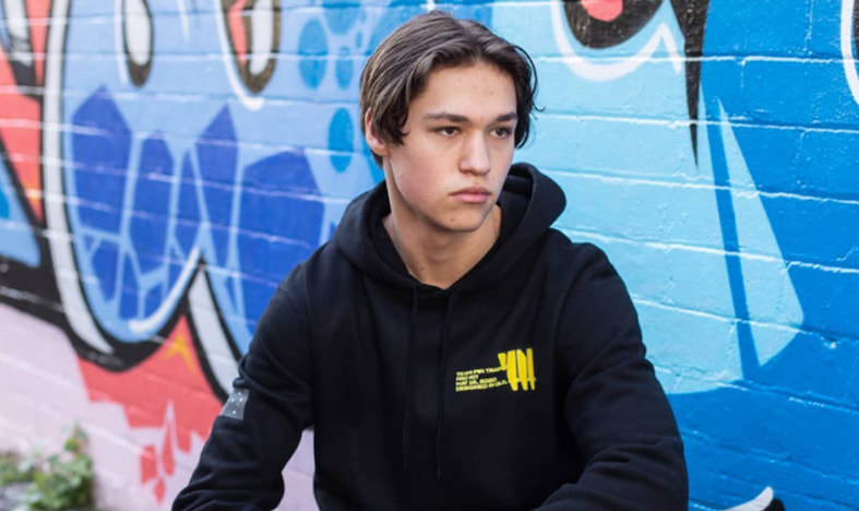 Esportspelaren RepulseGod poserar med ett självsäkert uttryck, klädd i gaming-merch.