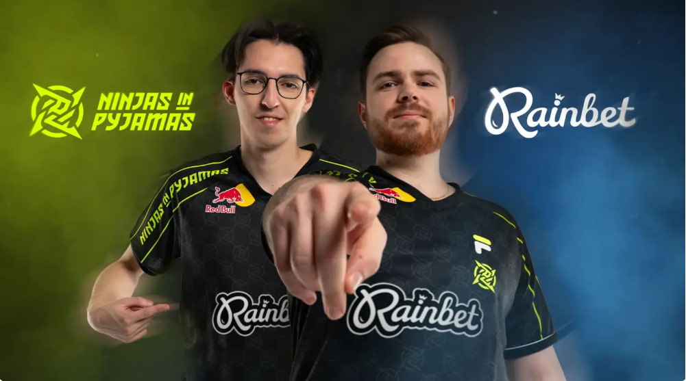 Två personer i Ninjas in Pyjamas-tröjor poserar framför logotyperna för Ninjas in Pyjamas och Rainbet.