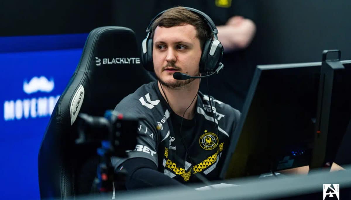 En e-sportspelare från Team Vitality sitter vid datorn under en tävling, med headset och lagtröja.