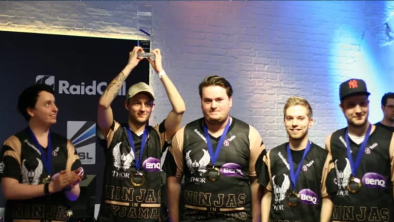 E-sportlaget Ninjas in Pyjamas firar seger på scen med medaljer och pokal.