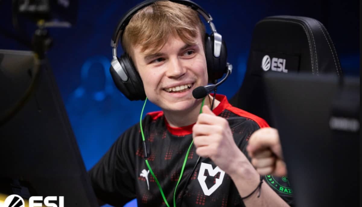 En esportspelare i svart och röd lagtröja spelar vid en dator under en ESL-turnering.