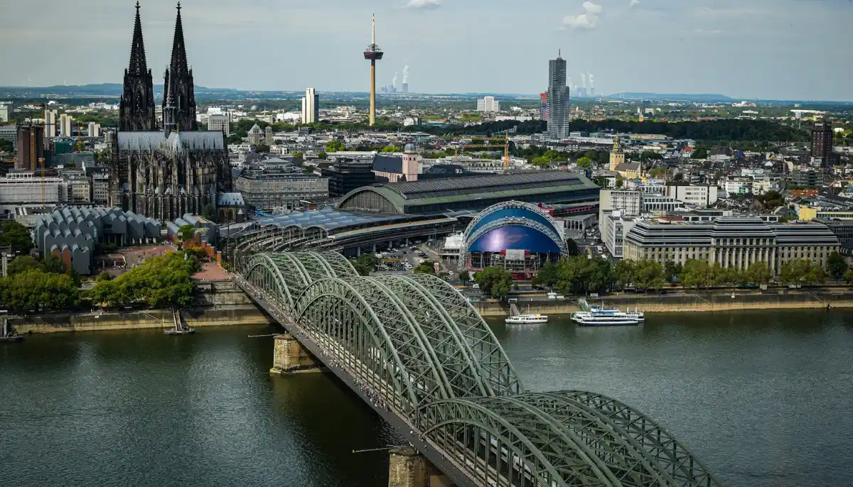 Vy över Köln med den ikoniska katedralen, järnvägsbron och floden Rhen i förgrunden.