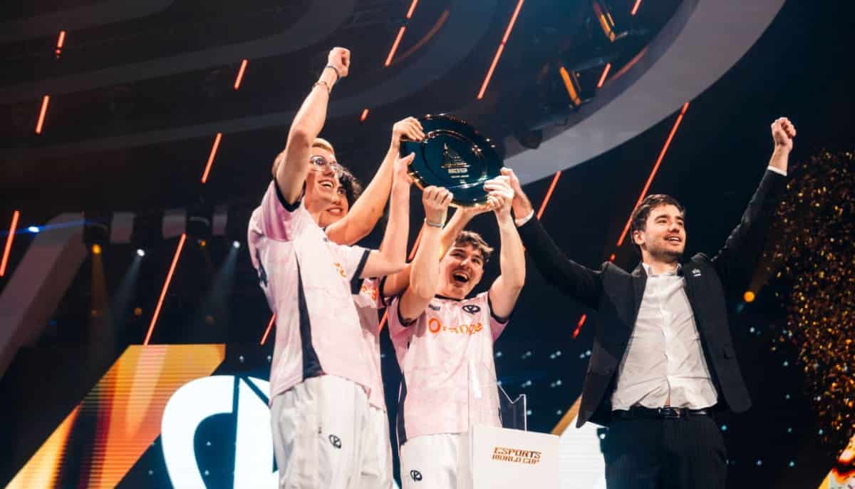Ett e-sportlag firar segern och lyfter en pokal på scenen under Esports World Cup.