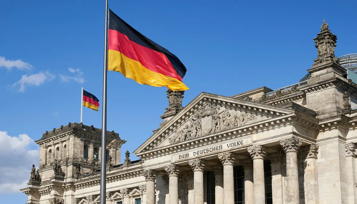 Tysk flagga vajar framför riksdagshuset i Berlin under en klarblå himmel.