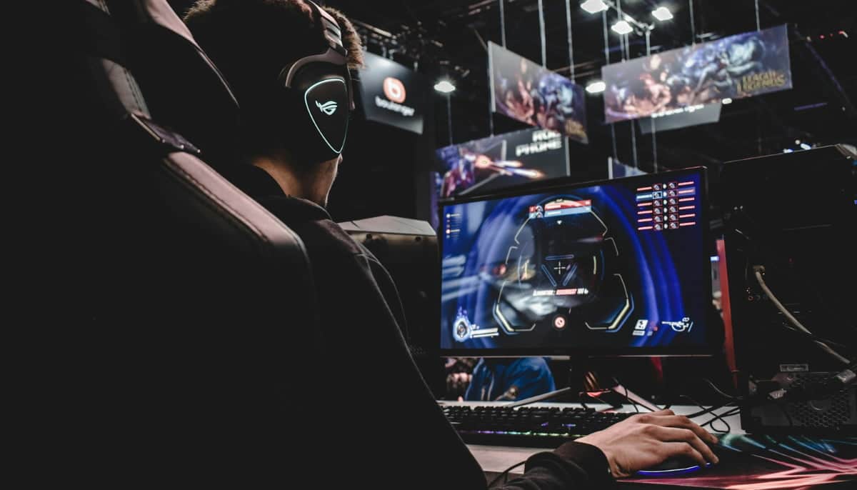 E-sportspelare med headset som tävlar vid dator under ett LAN-evenemang.