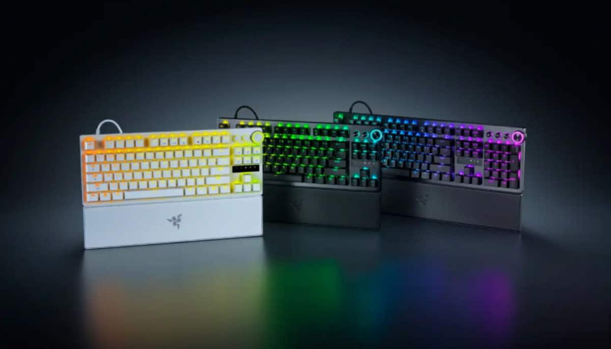 Tre Razer-tangentbord med färgad RGB-belysning i gult, grönt och lila på mörk bakgrund.
