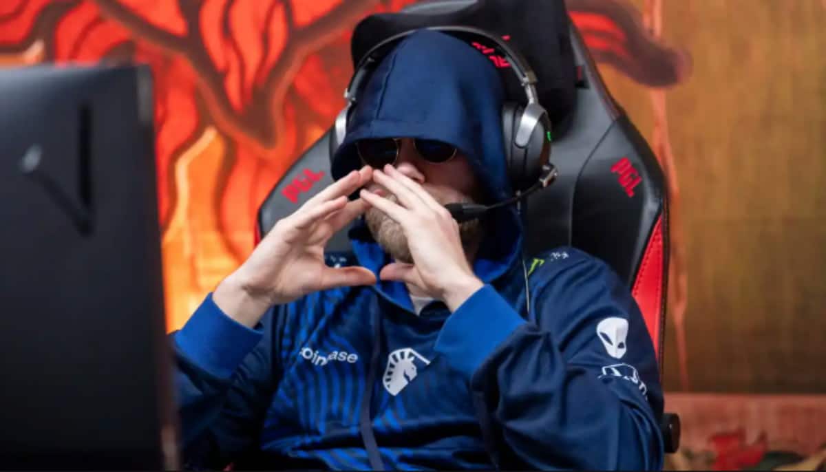 En e-sportspelare i mörk hoodie och headset sitter koncentrerat framför skärmen under en tävling.
