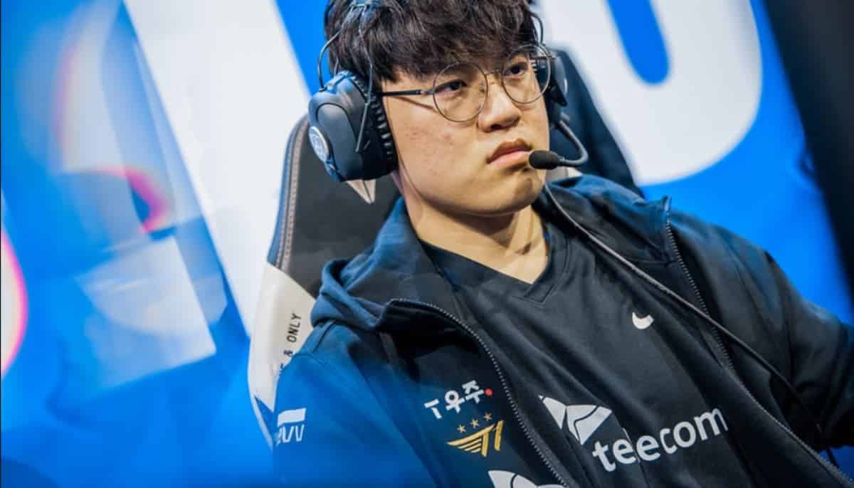 E-sportspelare i svart lagtröja med headset och mikrofon fokuserar vid datorn under match.