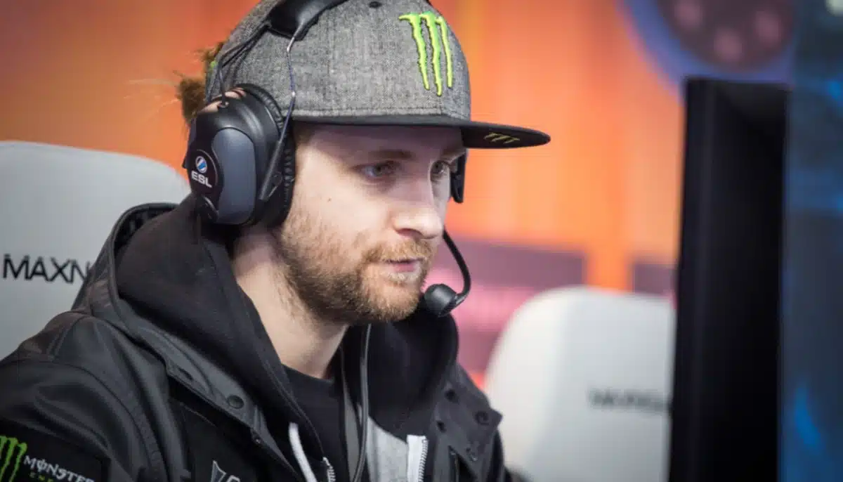 E-sportspelare med headset och keps fokuserar på skärmen under pågående match