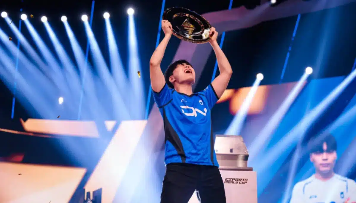 E-sportspelare firar seger genom att lyfta en pokal på scen under Tekken-turnering i Esports World Cup.