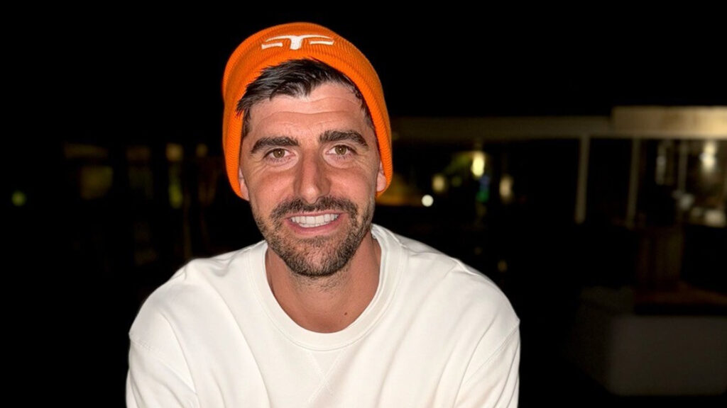 Image of Thibaut Courtois smiling while wearing a Federation of Sport beanie hat