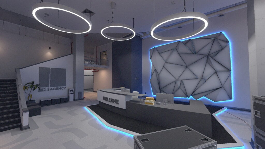 A sleek, modern lobby interior from the Agency map in Counter-Strike 2, featuring futuristic ring lights, a geometric illuminated wall, and a reception desk with a “Welcome” sign.
