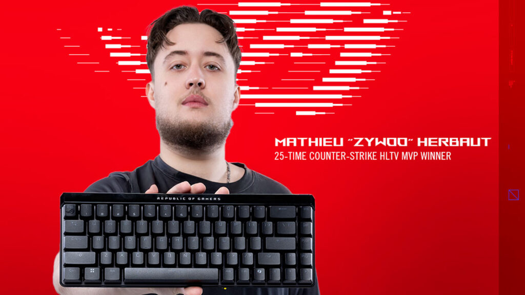 Image of ZywOo holding an ASUS ROG keyboard while standing in front of a red and white background.