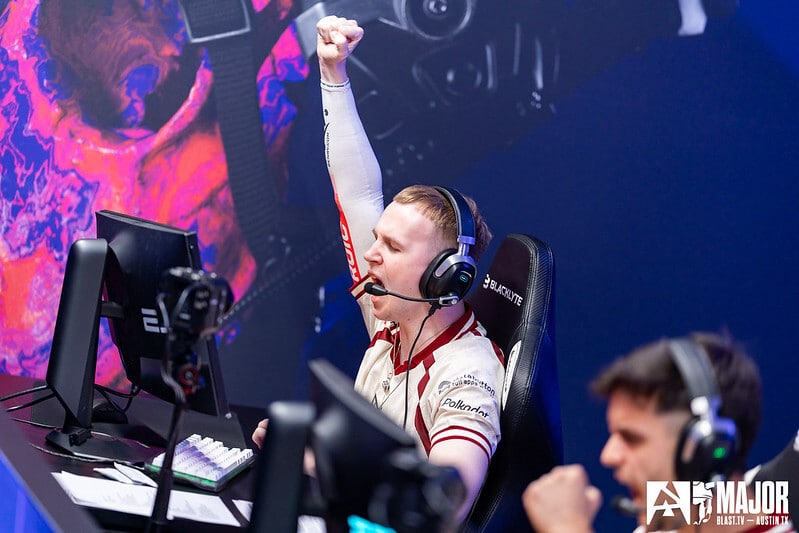 Image of HEROIC Counter-Strike player fist pumping the air while looking at PC monitor.
