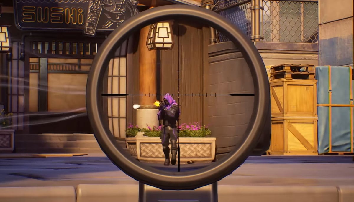 Sniper scope view focused on a character in a purple hood shooting, with crates and a sushi restaurant in the background
