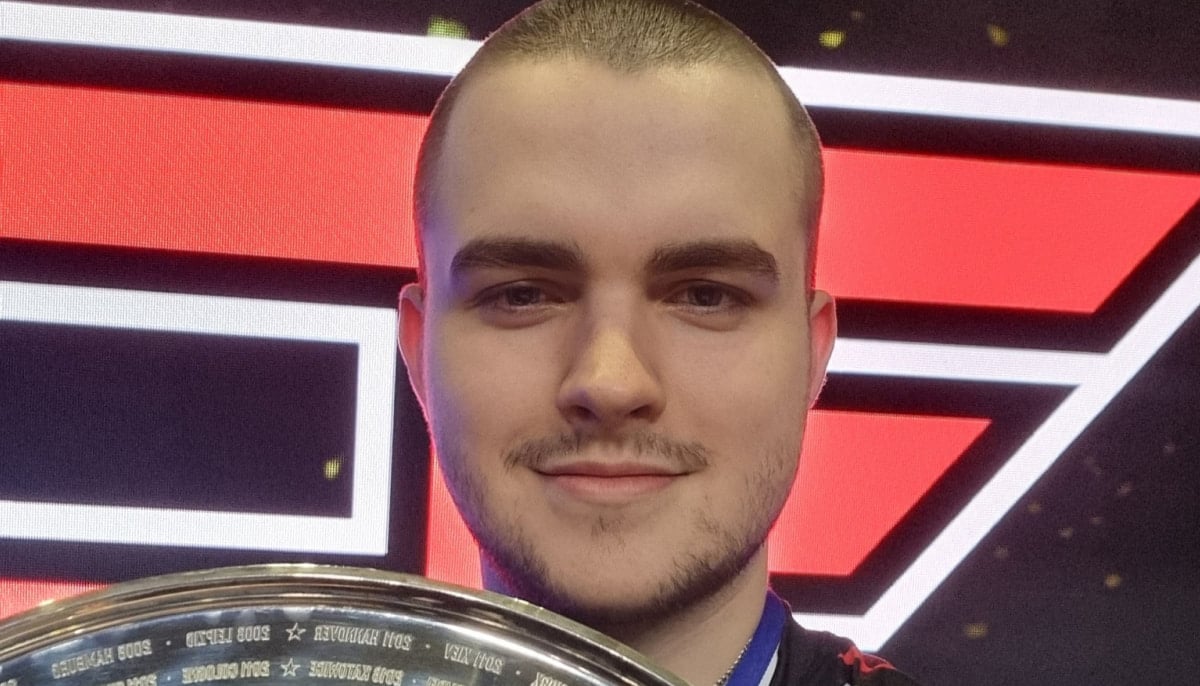 Broky holding a shiny award, with a colorful, geometric red and black background