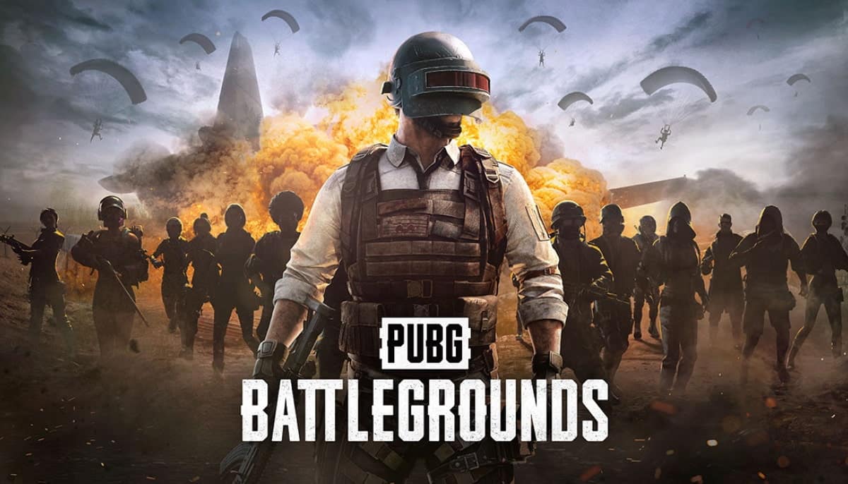 A soldier of PUBG in tactical gear stands confidently amid a smoky battlefield, backed by silhouetted troops and descending parachutes