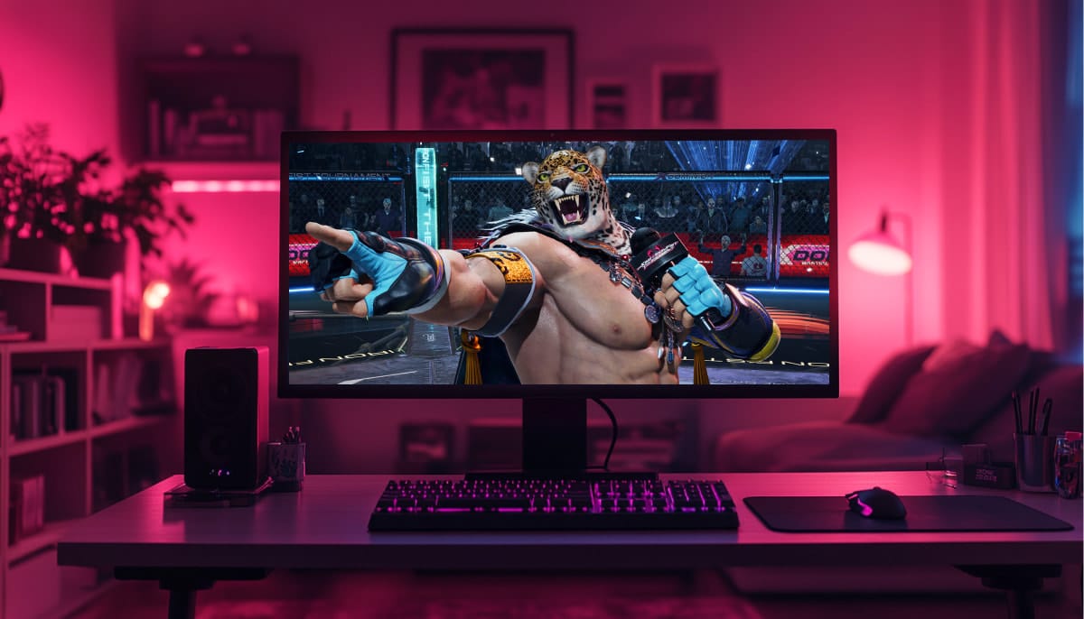A desktop sits in a dimly lit room with a vibrant pink glow. On the screen, a muscular character with a jaguar mask named King passionately gestures