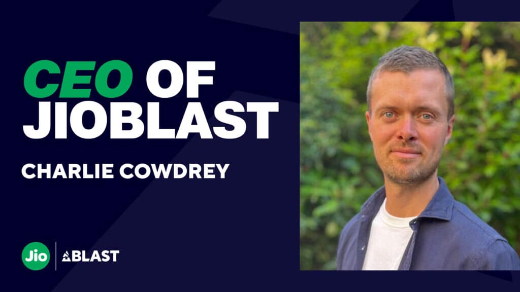 Image of Charlie Cowdrey smiling while standing in front of green plants. The left of the image contains white and green text along with the JioBLAST logo in the bottom left corner.