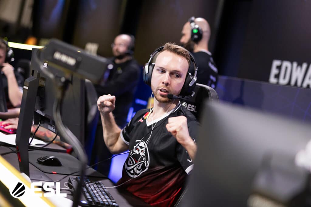 Image of Gla1ve competing in Counter-Strike event while wearing ENCE jersey. Gla1ve is holding his fists in the air.