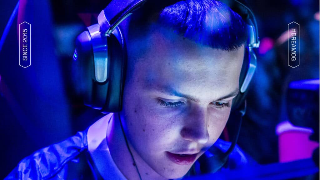 Image of F1KU competing at Counter-Strike event. The player is illuminated with a blue light and is wearing a headset