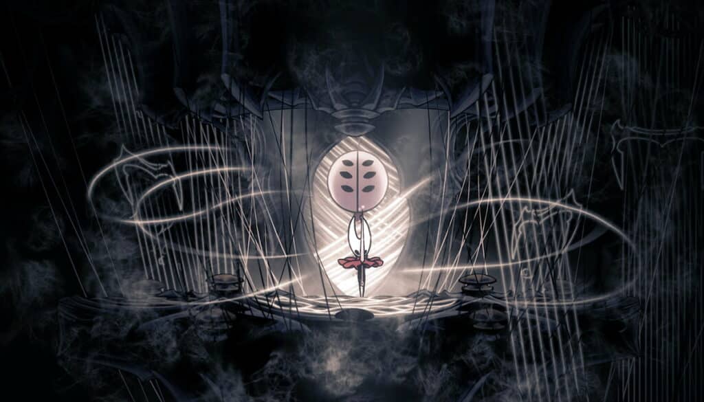 Hornet suspended in glowing threads inside a dark chamber in Hollow Knight Silksong.
