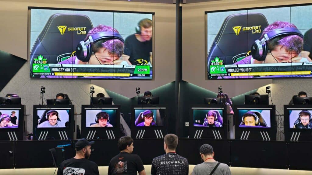 Image of Fragadelphia stage with people sat watching matches on screens in the foreground