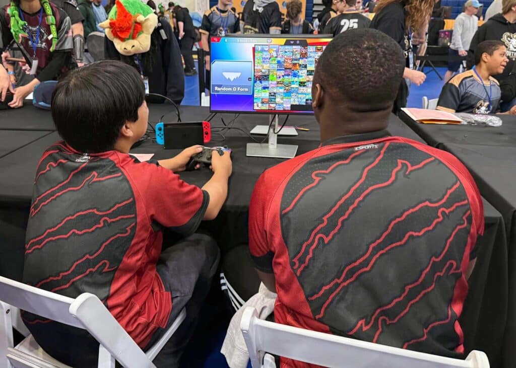 Image of collegiate esports players playing video game on Nintendo Switch console. The console and monitor are placed on the table in the background