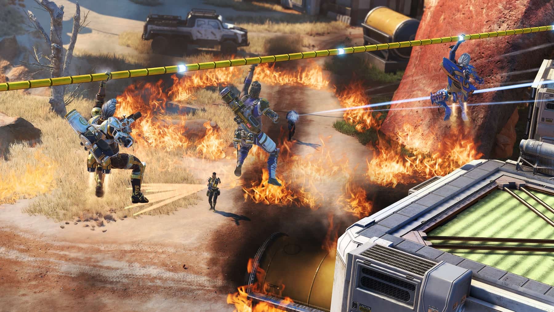 Three armored characters zip-line over a fiery landscape. Flames and smoke rise below, creating tension