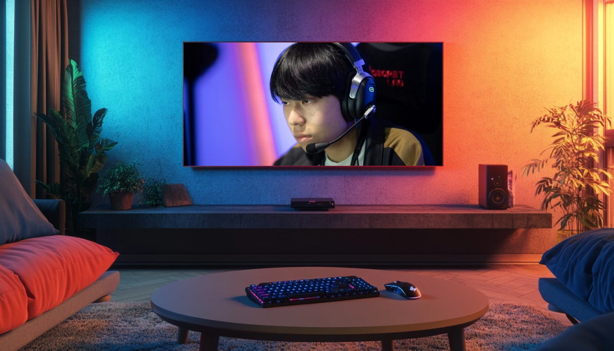 A living room with a large TV showing a focused gamer wearing headphones