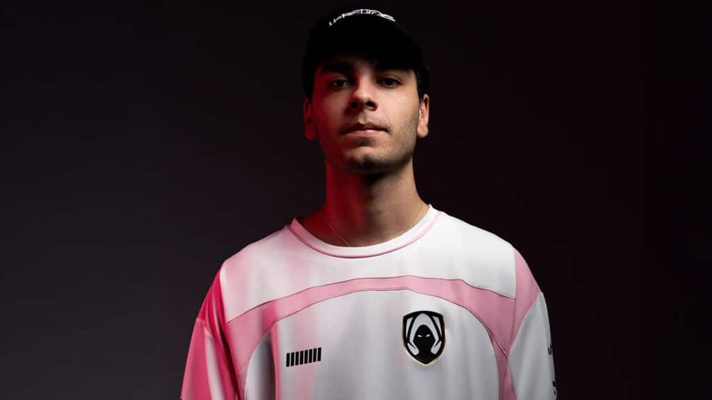Image of person wearing Team Heretics jersey and a black cap with Heretics written across the front in white