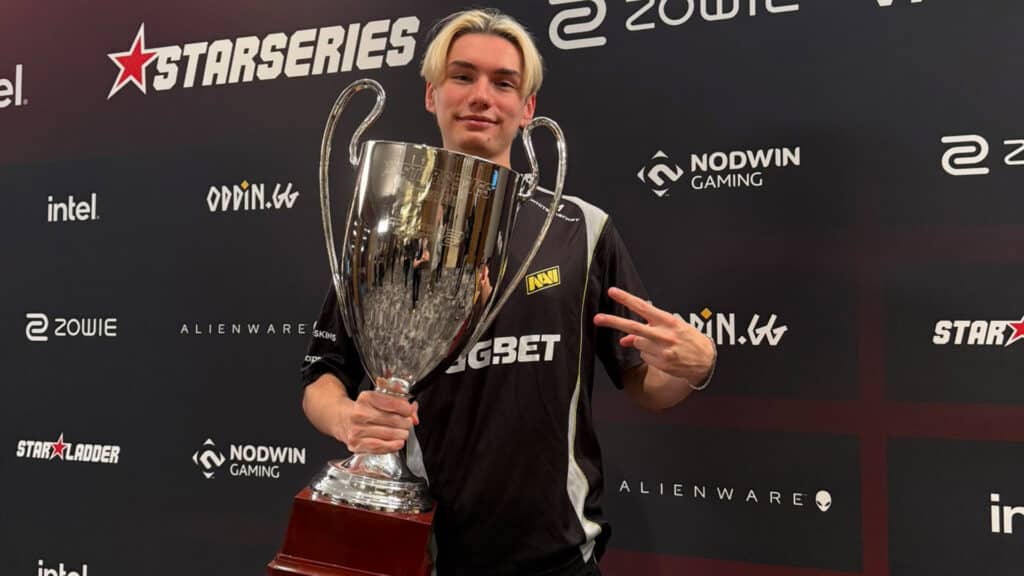 Image of NAVI Counter-Strike player w0nderful holding StarLadder StarSeries Season 19 trophy on a sponsor background