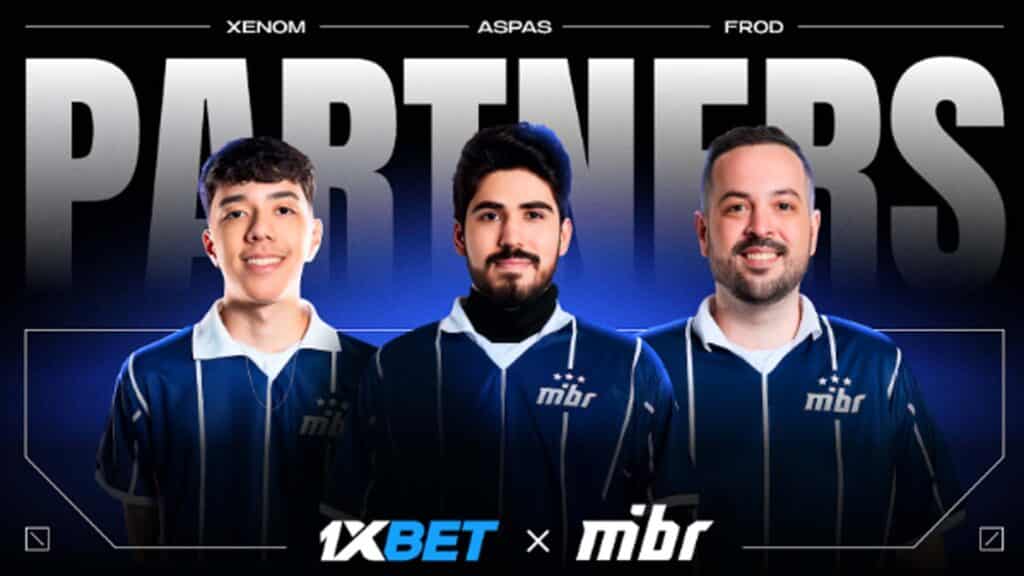 Image of MIBR Valorant players smiling while wearing a blue and white jersey. Underneath the players are the 1xBet and MIBR logos on a black background