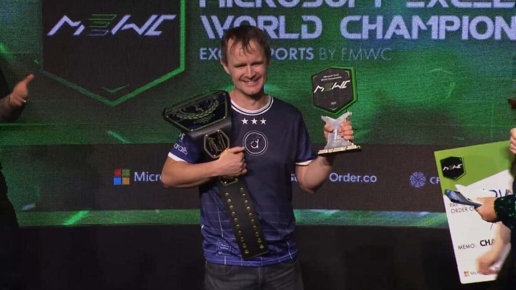 Image of Diarmuid Early holding Microsoft Excel World Championship trophy and championship belt