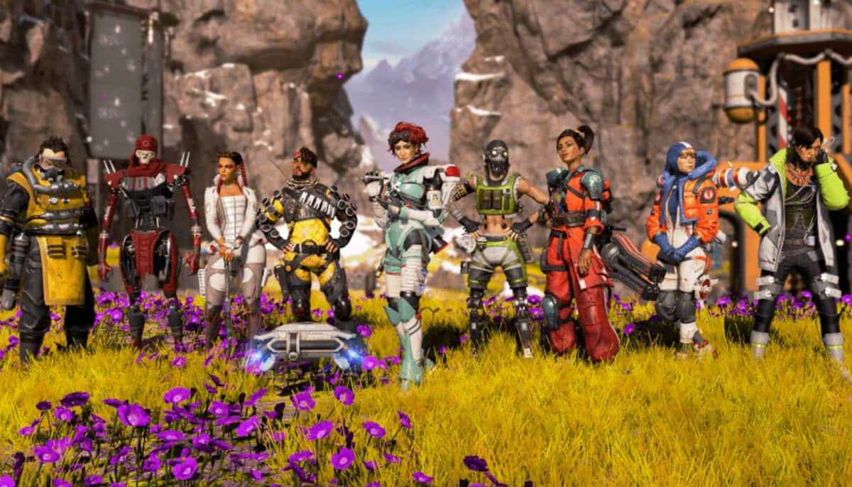 A lineup of various Apex Legends characters in different skins standing in a grassy field with purple flowers