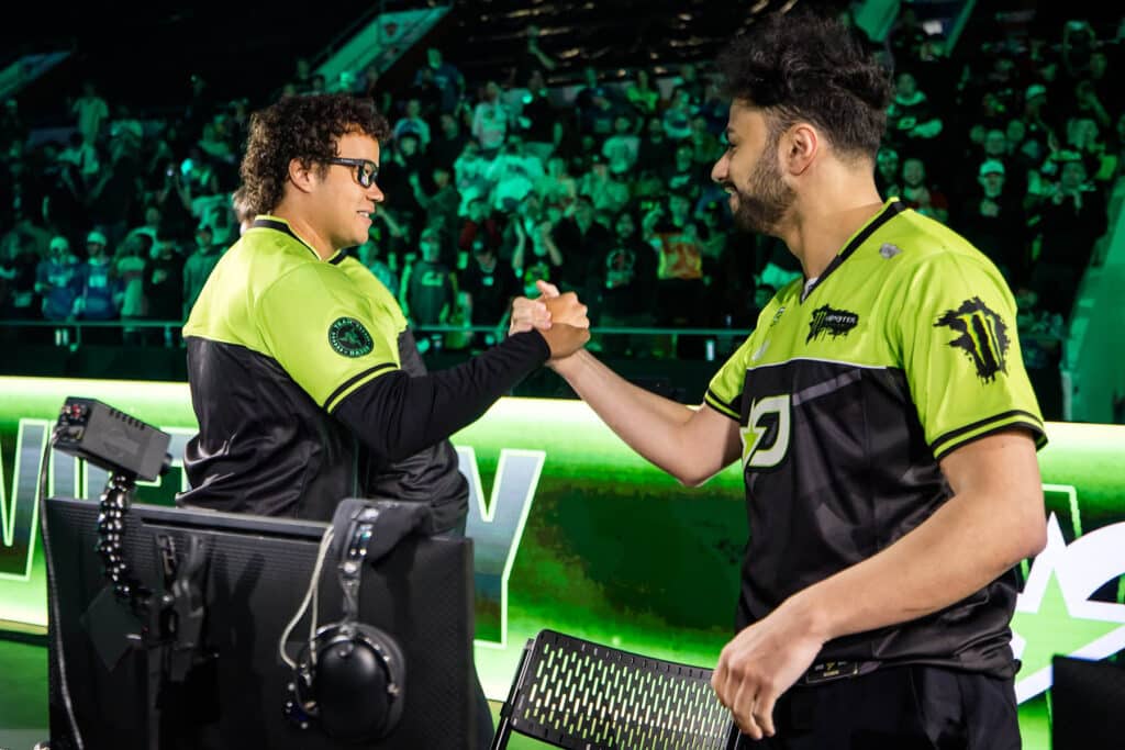 Image of OpTic Texas players Huke and Dashy shaking hands while competing on stage