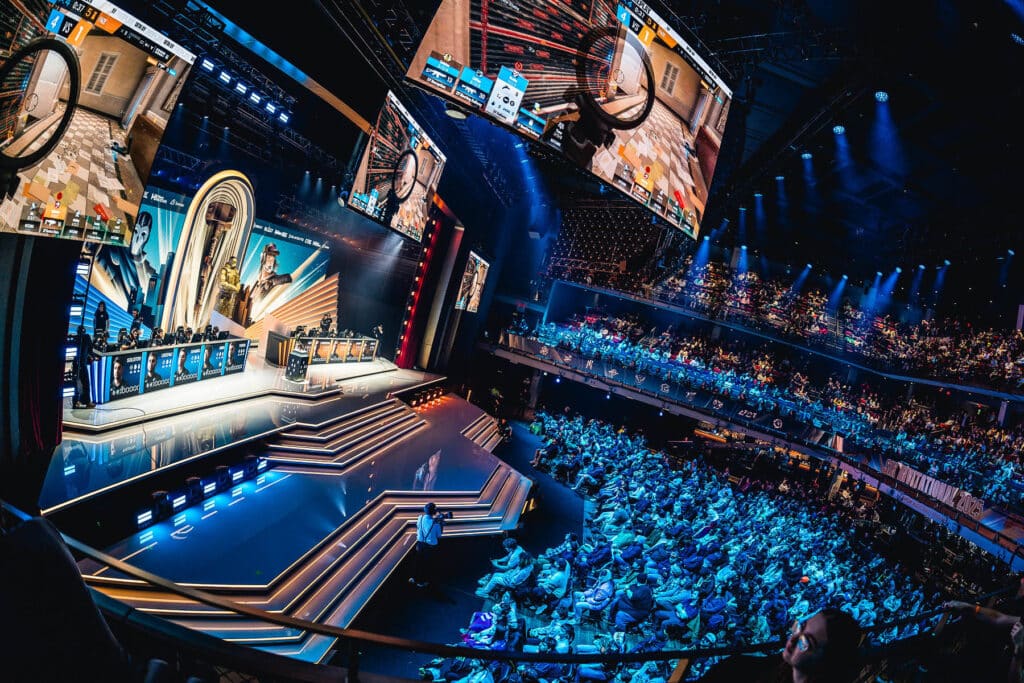 Image of Six Invitational 2025 main stage with crowd of people sat watching Rainbow Six gameplay on large screens