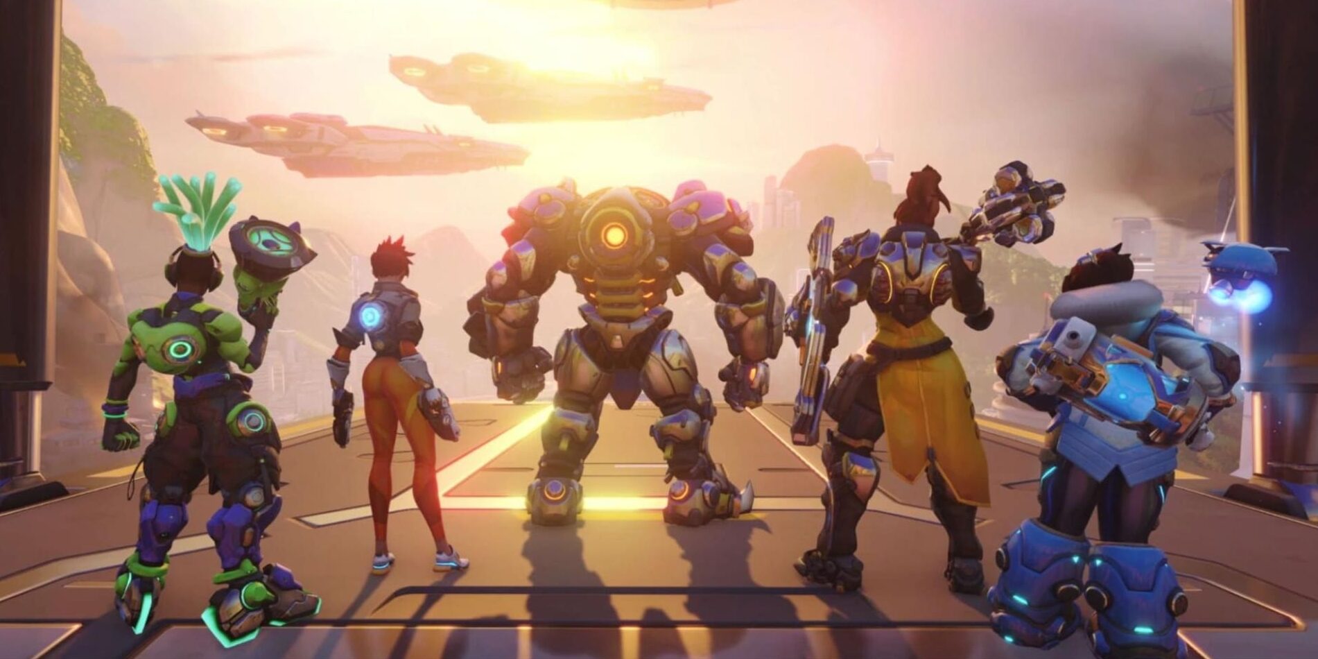 An illustration of several characters from the video game Overwatch 2 standing in a line in what appears to be a hangar or base. The characters include (from left to right): the support hero Lúcio, the damage hero Tracer, a large robotic enemy from the Null Sector faction (likely a Subjugator or similar unit from the PvE missions), the support hero Brigitte, another Null Sector robot, and the damage hero Mei