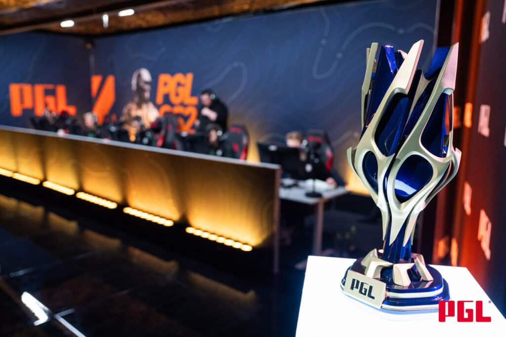 Image of PGL Bucharest trophy next to a Counter-Strike team competing on stage