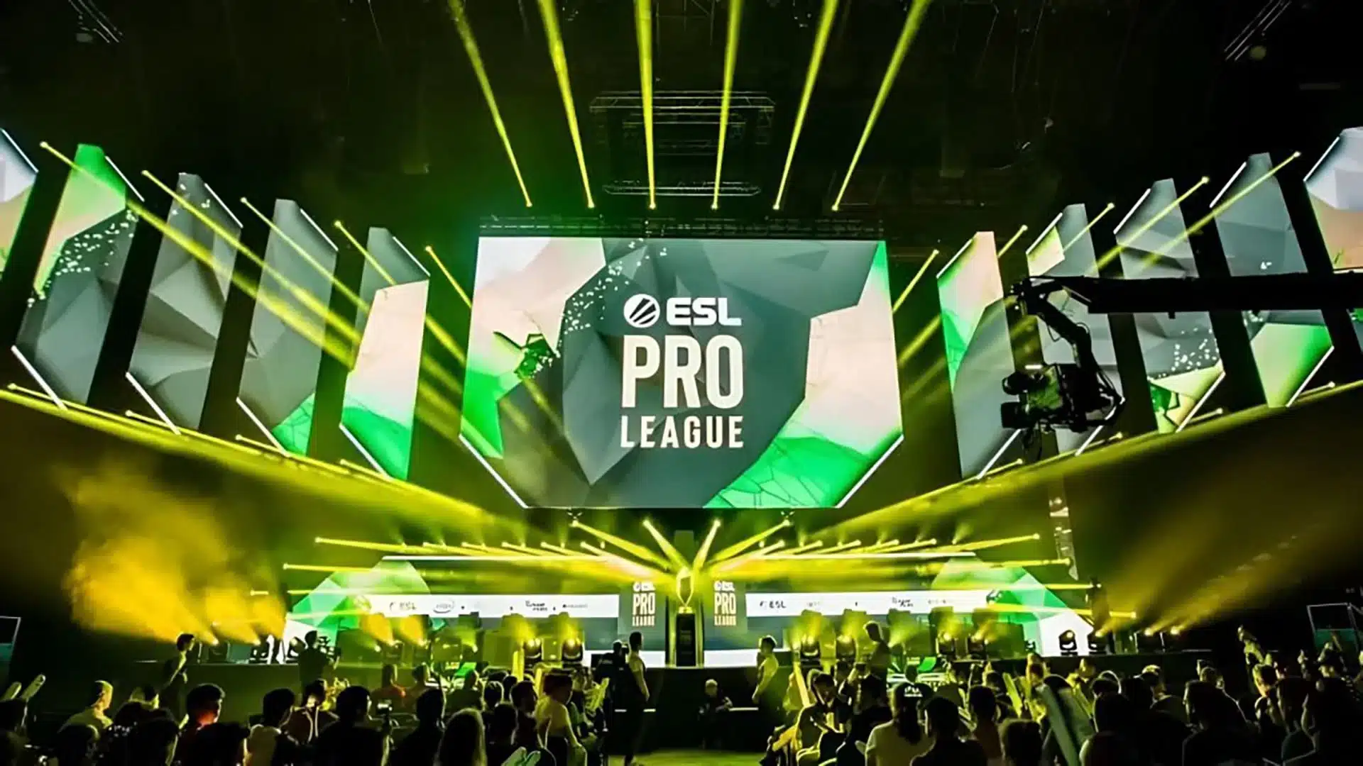 An ESL Pro League tournament stage with large screens and yellow spotlights over a crowd.